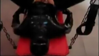 A Dominatrix Vestida De Látex Domina Seu Escravo Strapon Em Uma Cena Bdsm